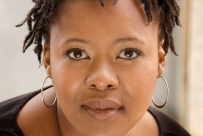 a close up photo of a black women wearing a black top