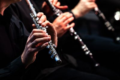 Image of hands playing a flute and two other woodwind instruments