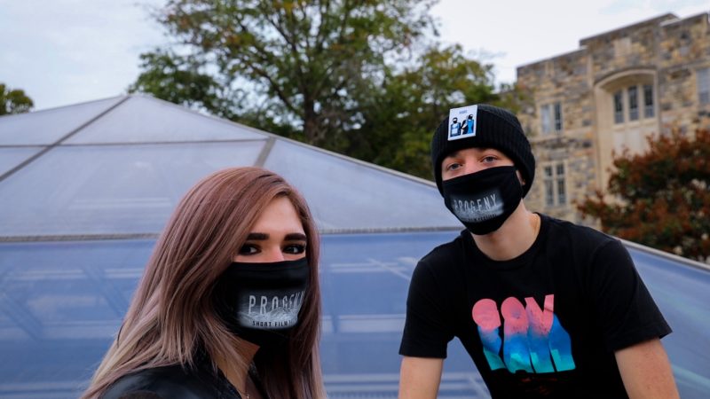 Two college students outdoors wearing facemasks