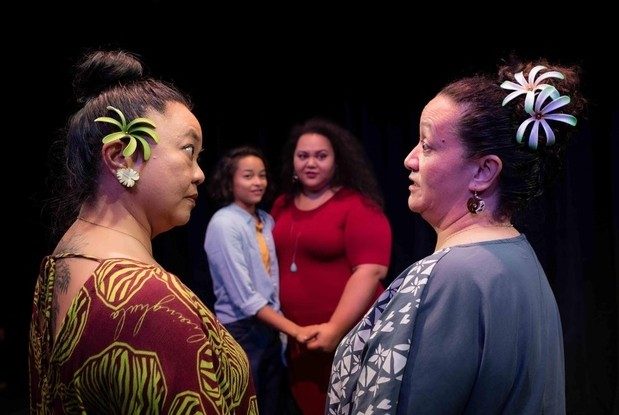 A happy same-sex Samoan couple is framed in the background by their mothers in the foreground look at one another in Kumu Kahua Theatre's Fa'Alavelave "The Interruption" (2019)