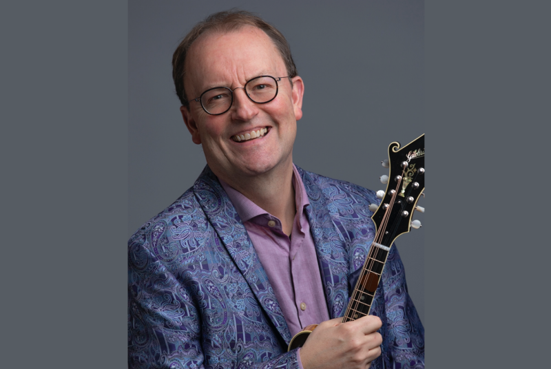 Musician Jeff Midkiff, smiling and holding a mandolin